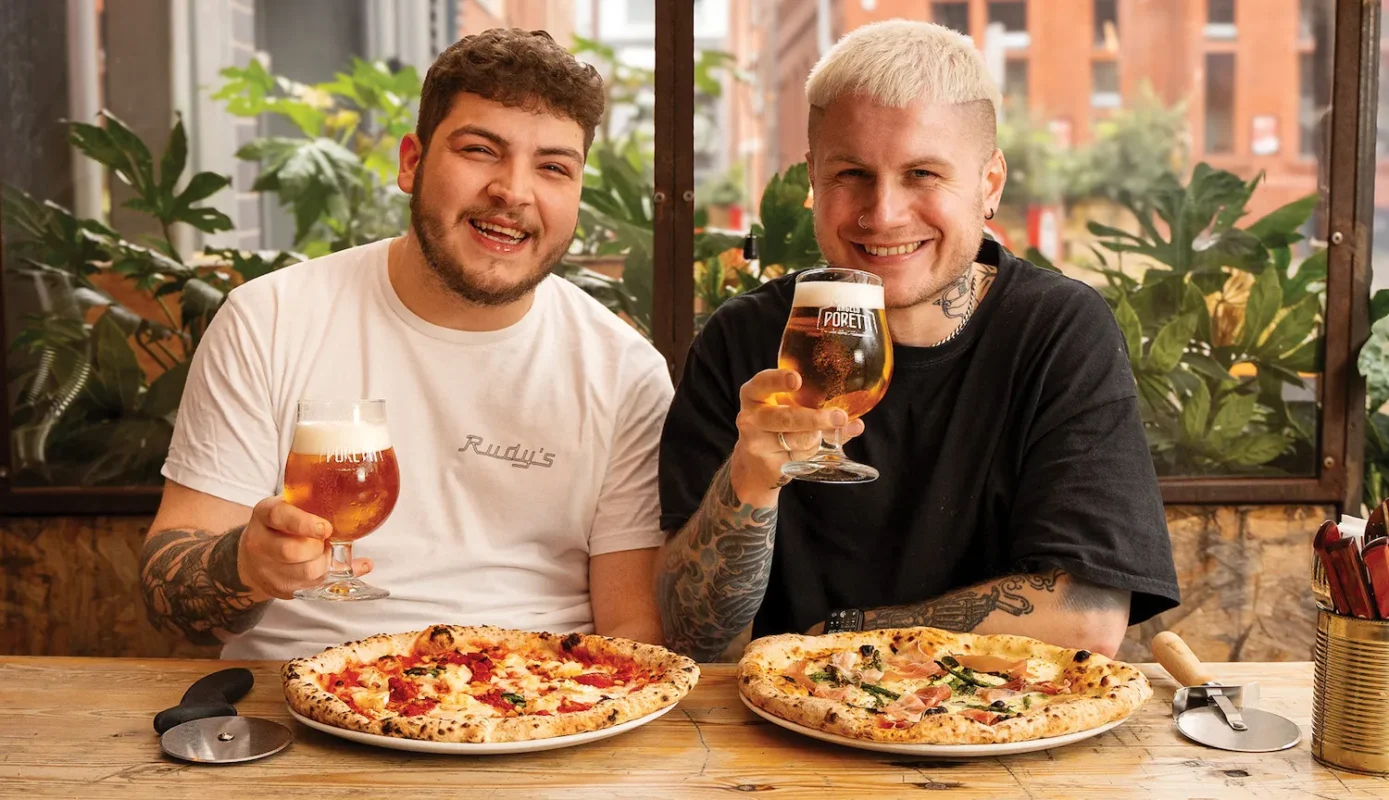 two men enjoying neapolitan style pizza and drinking beer