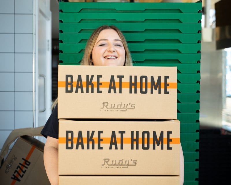 woman holing bake at home pizza boxes