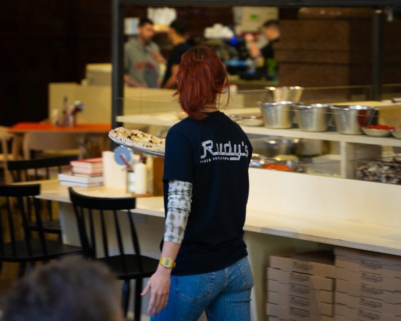 waiter holding neapolitan style pizza