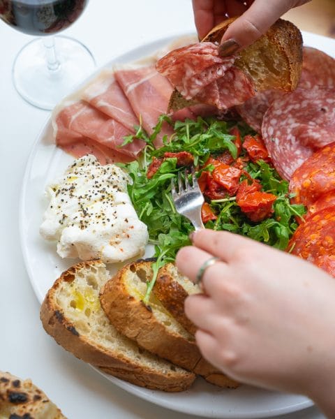 person grabbing authentic italian appetizers
