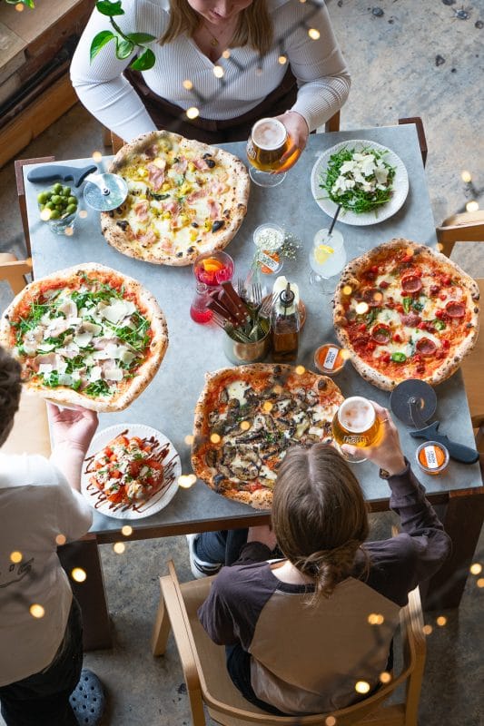group enjoying authentic neapolitan pizza at rubys pizzeria