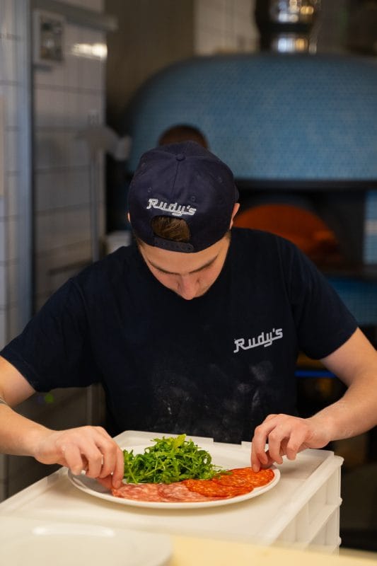 kitchen staff preparing plate of appetizers