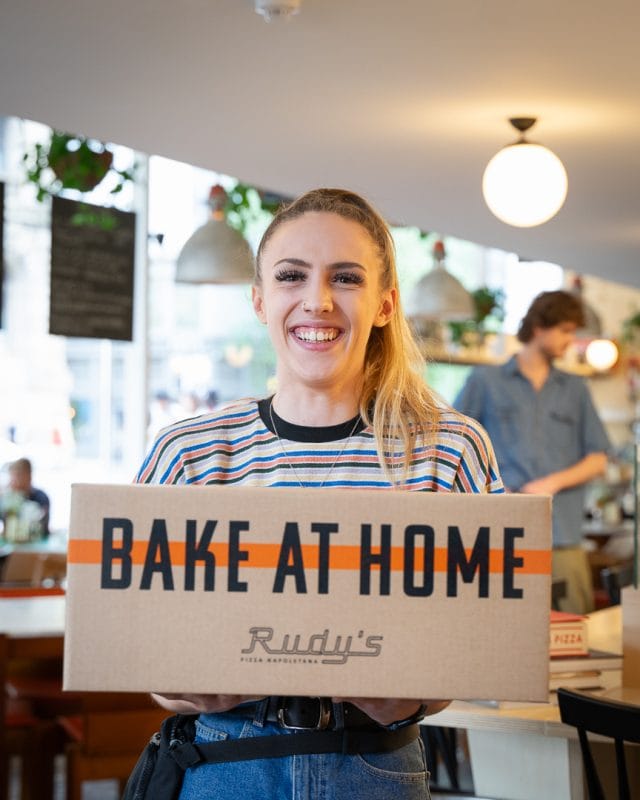 girl holding box with bake at home neapolitan pizza