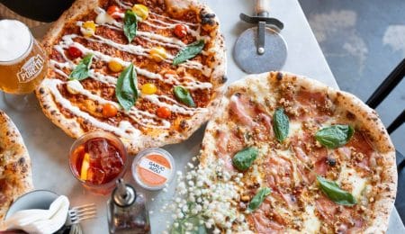 autumn specials, showing two pizzas on a tabletopped with basil