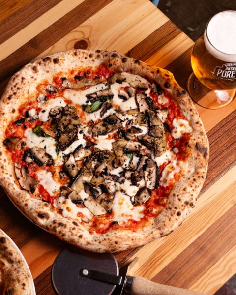 Pizza with tomatoes, mushrooms, mozzarella, parmesan and basil