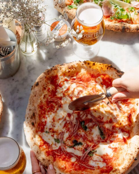 Pizza topped with tomatoes, salame, mozzarella, parmesan and basil