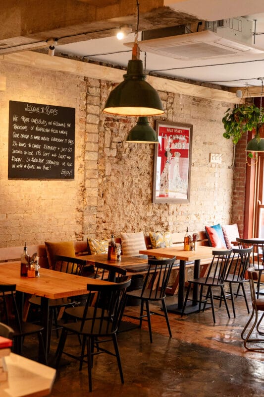 Interior of pizzeria at Rudy’s Cambridge, a warm and stylish