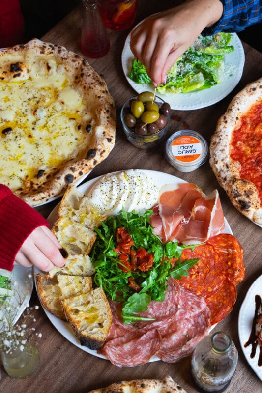 plate with appetizers and authentic neapolitan pizza