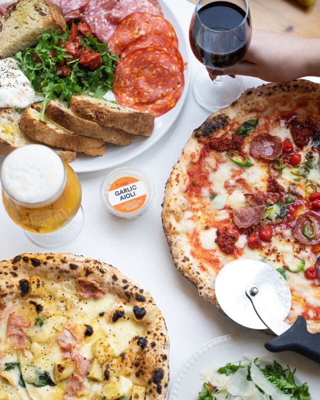 sides and pizza over table