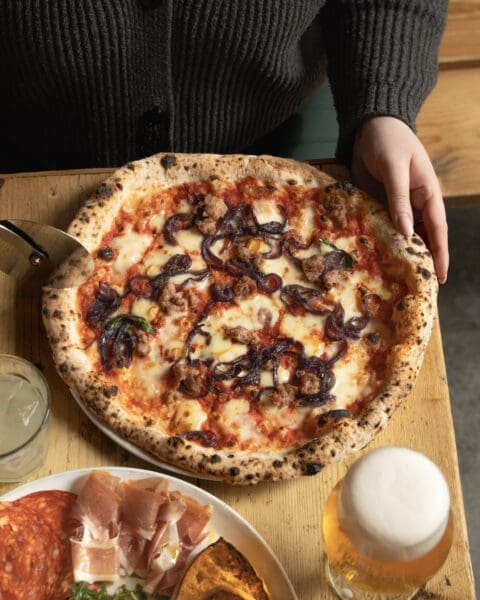 hand cutting pizza