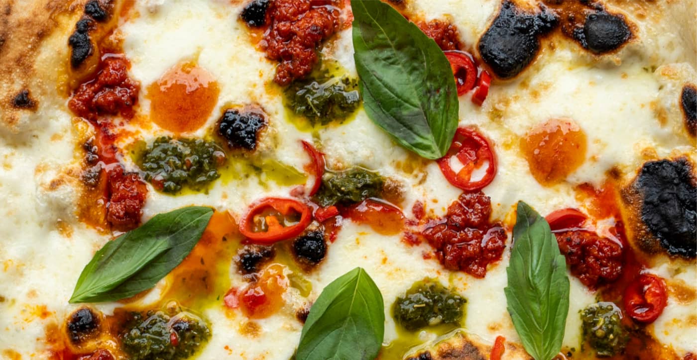 Philomena pizza topped with basil, pesto and chilli's